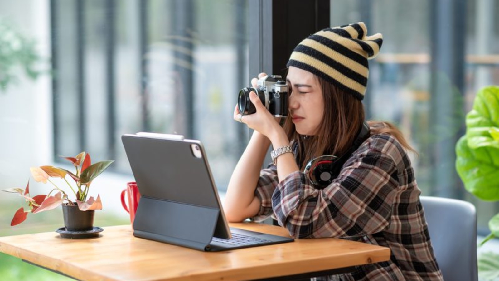 asian-woman-wearing-a-wool-hat-is-using-a-camera-2023-11-27-05-27-49-utc (1)