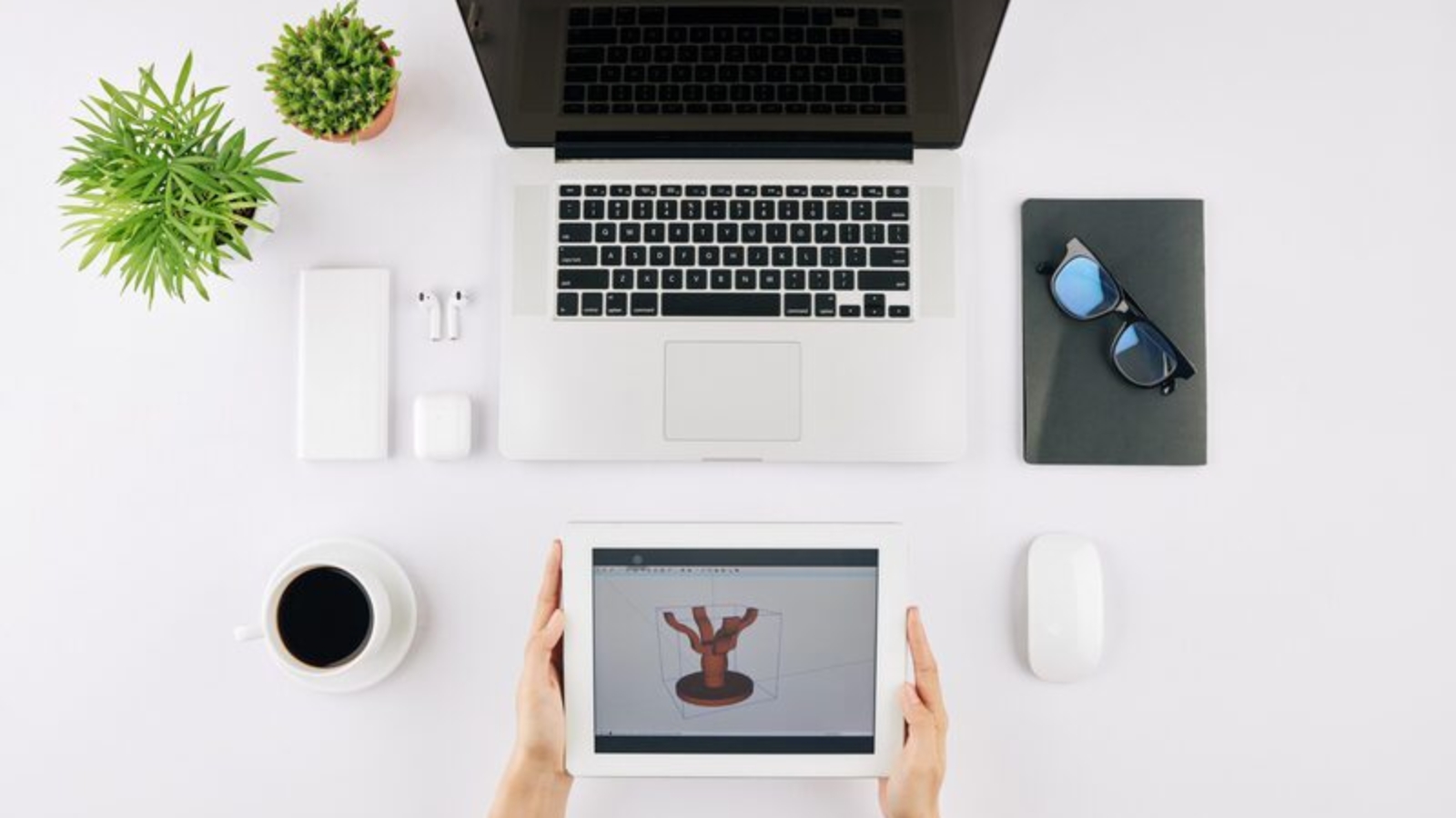 Designer checking wooden table visualization on tablet computer when working at desk in home office